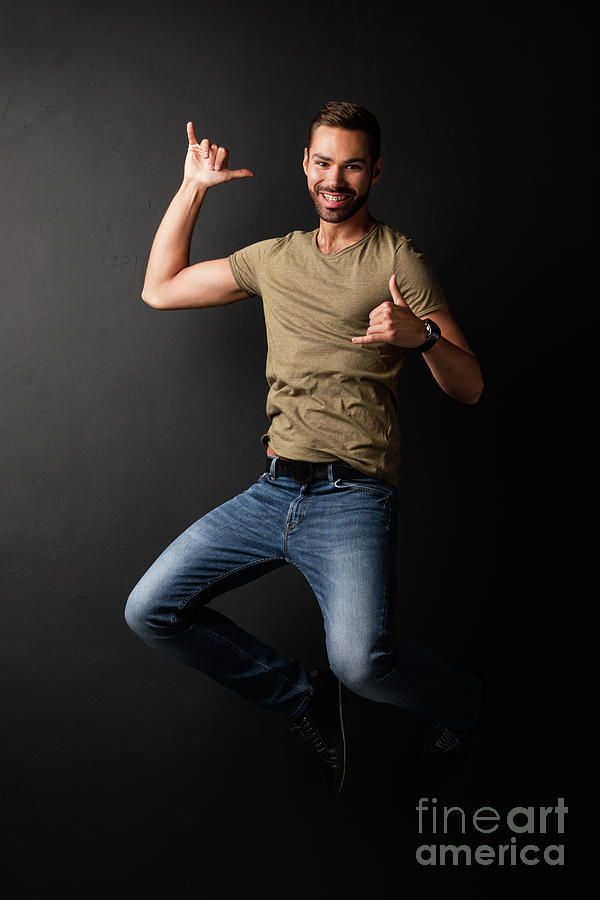 Happy handsome young man jumping and dancing Photograph by Michal Bednarek