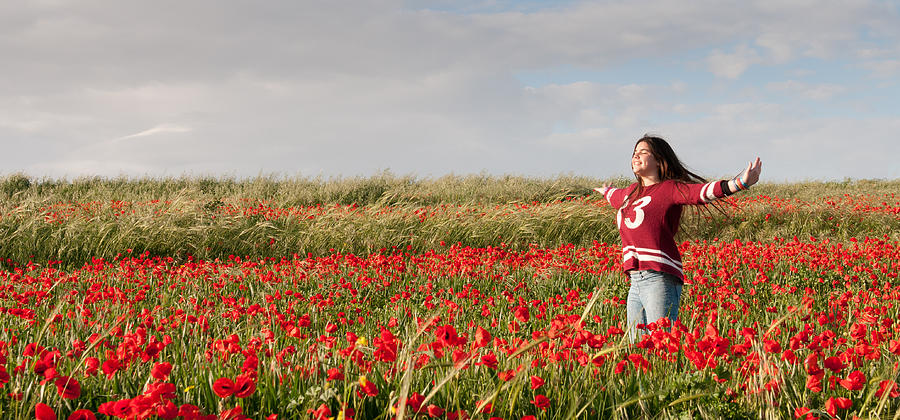 Happy Teenage Girl  in a red field of poppy flowers  Photograph by Michalakis Ppalis