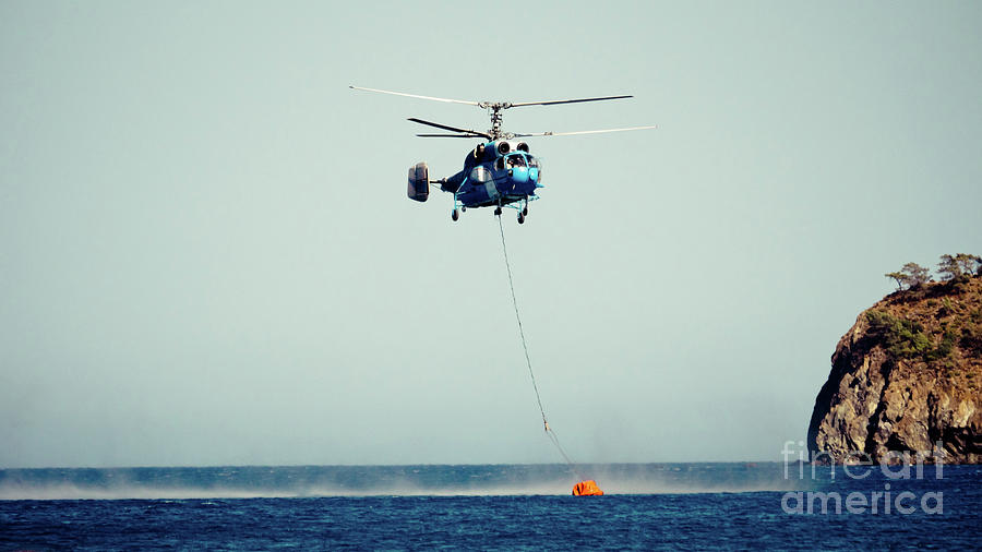 Helicopter firefighter take water in the sea Photograph by Raimond Klavins