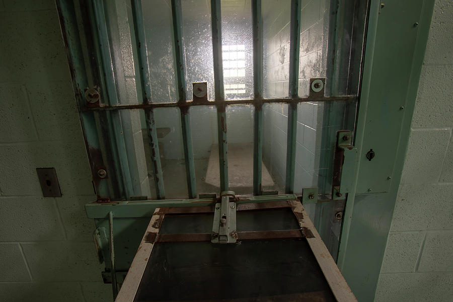 High risk solitary confinement cell in prison through bars Photograph by Karen Foley