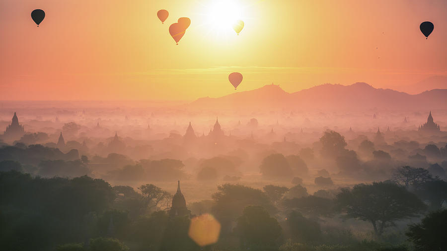 Sunset Photograph - Hot air balloon over plain and pagoda of Bagan in misty morning by Anek Suwannaphoom