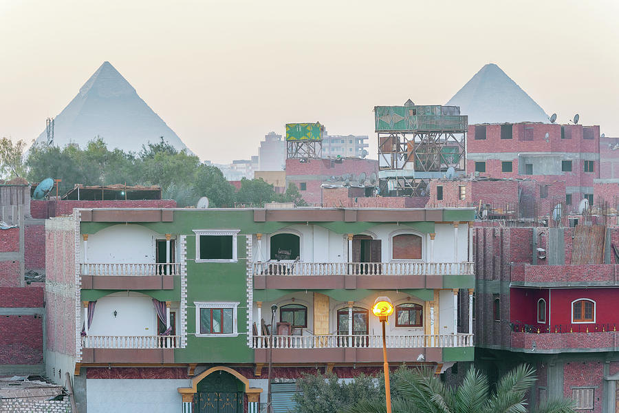 Houses in Cairo and pyramids of Giza at the background Photograph by Marek Poplawski
