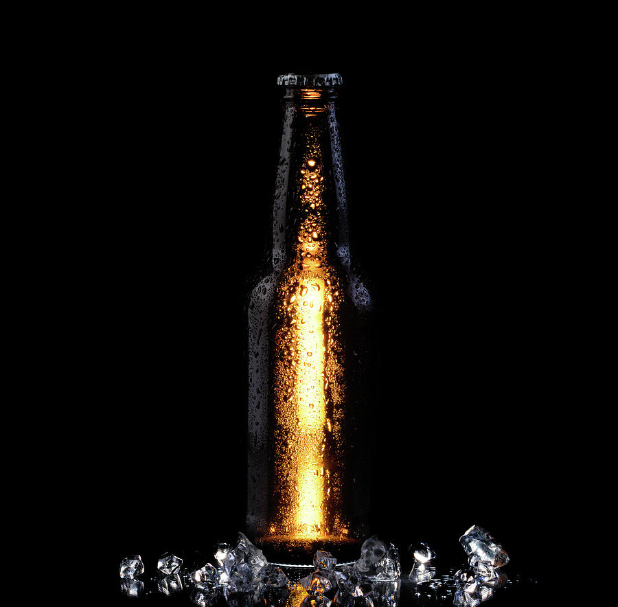 Ice cold bottle of beer on black background by Thomas Baker