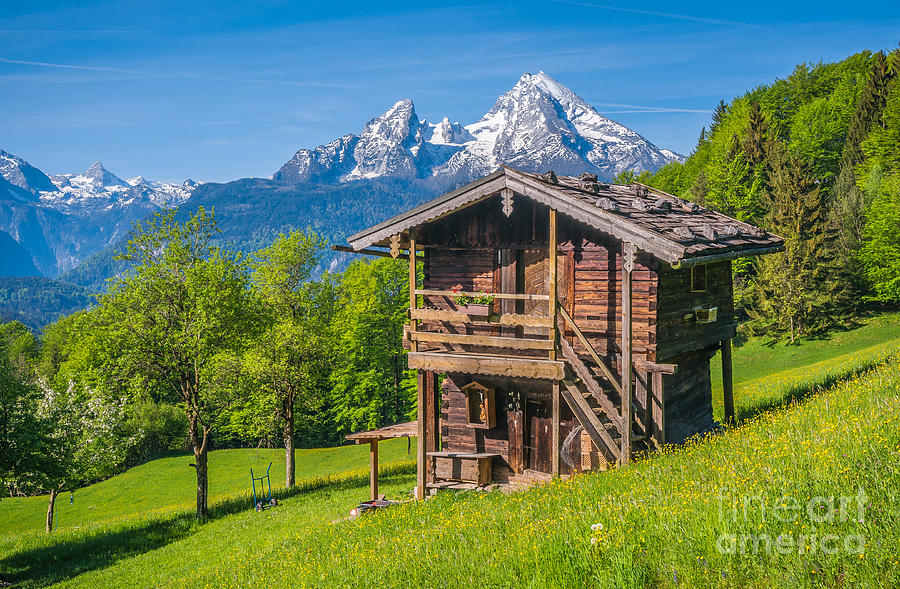 Idyllic springtime landscape in the Alps with traditional mountain lodge and fruit trees Photograph by JR Photography