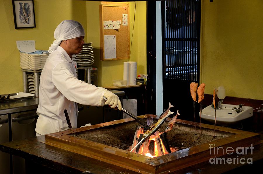 Japanese chef in kitchen grills fish on indoor coal fire Tokyo Japan Photograph by Imran Ahmed