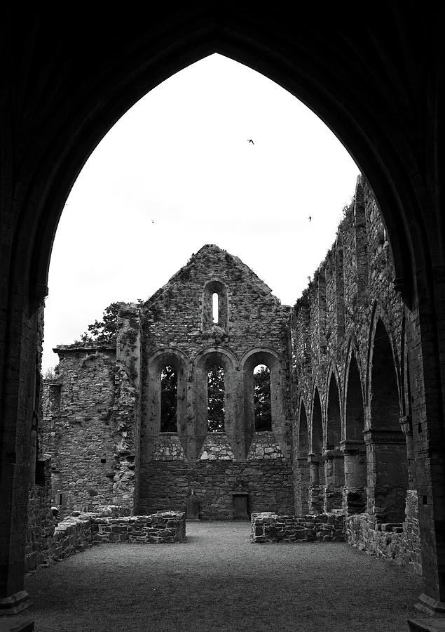 Jerpoint Abbey Framed By Arch Medieval 12th Century Ruins County Kilkenny Ireland Black and White Photograph by Shawn OBrien