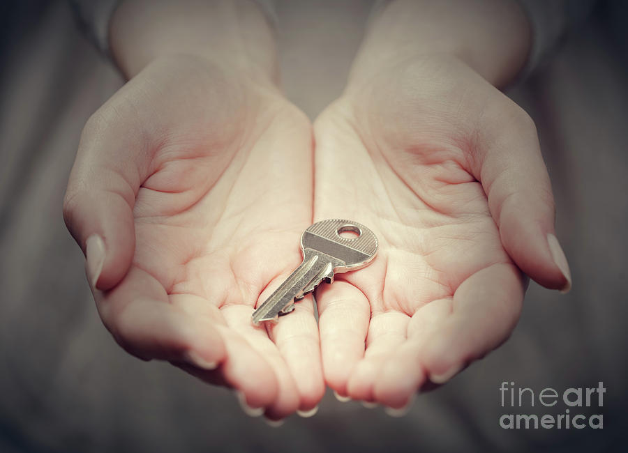 Key in womans hand in gesture of giving. Concept of success in live, business solution, real estate etc Photograph by Michal Bednarek