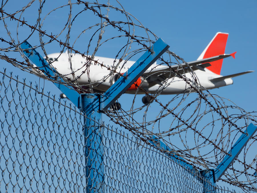 Landing airplane behind barbed wire Photograph by Miroslav Nemecek