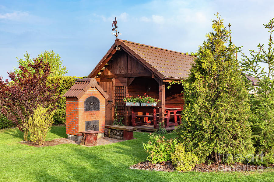 Landscaped summer garden with barbecue and wooden summerhouse Photograph by Michal Bednarek