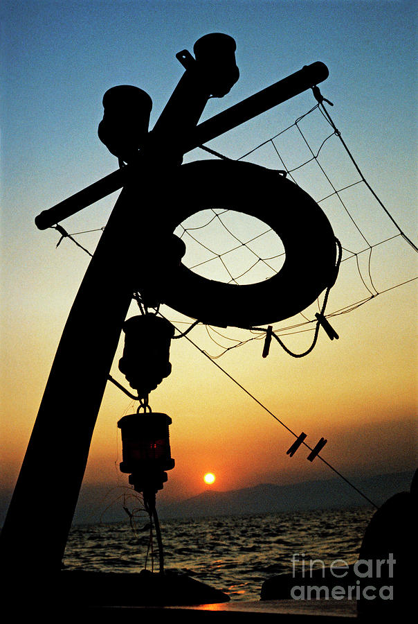 Lifebuoy silhouetted on a fishing boat at sunset Photograph by Sami Sarkis