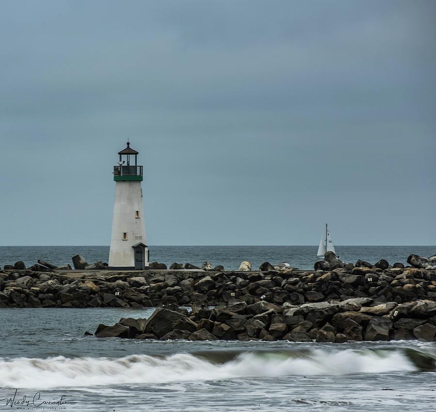 Lighthouse and Sailboat Photograph by Wendy Carrington