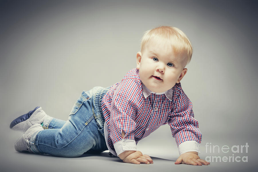 Little blond baby boy crawling on the ground. Photograph by Michal Bednarek