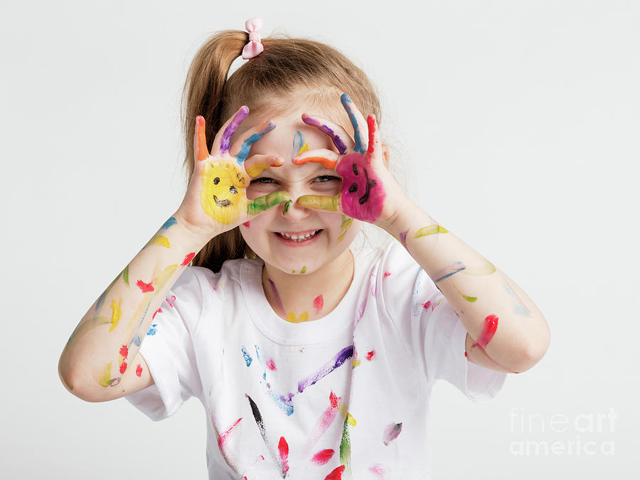 Little girl covered in paint making funny faces. Photograph by Michal Bednarek