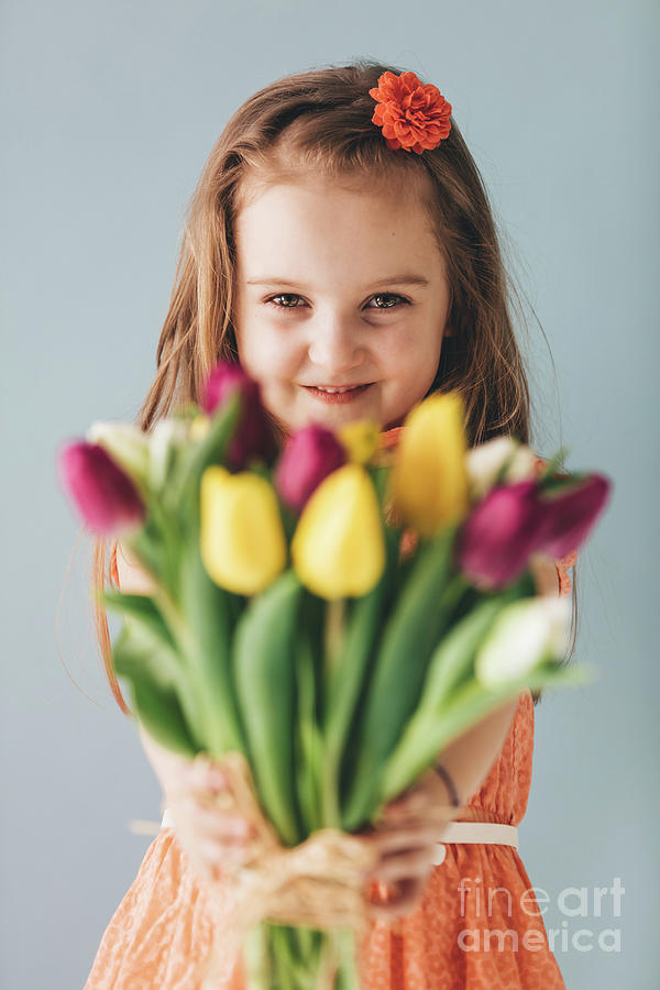 Little girl giving colorful flowers, smiling sincerely Photograph by Michal Bednarek