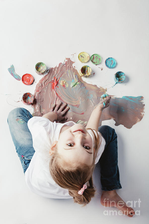 Little girl painting with her hands on the floor. Photograph by Michal Bednarek