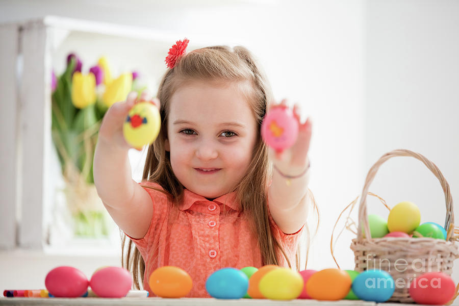 Little girl showing her hand-painted colorful eggs. Photograph by Michal Bednarek