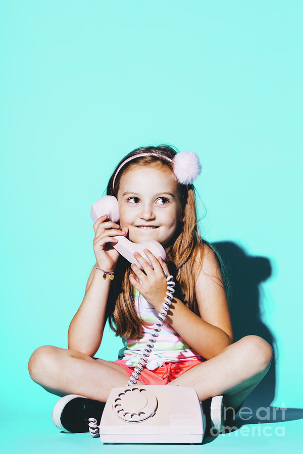 Little girl using pink analogue phone Photograph by Michal Bednarek