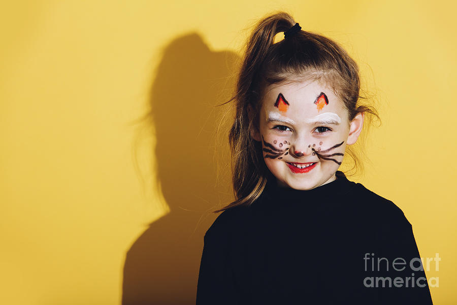 Little girl with cat makeup on her face. Photograph by Michal Bednarek