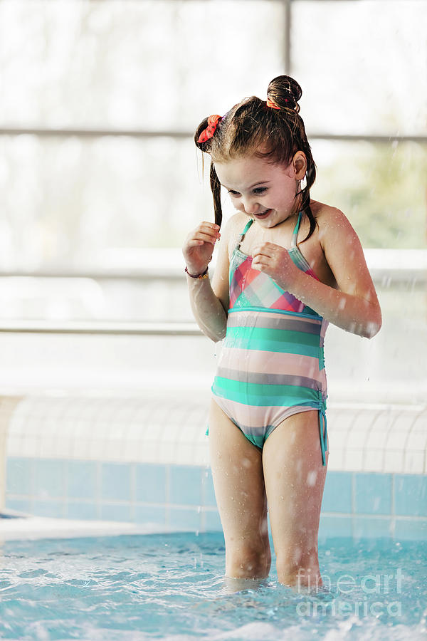 Little girl with wet hair standing in a kids pool. Photograph by Michal Bednarek