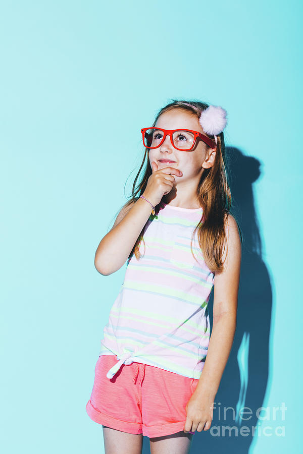 Little pensive girl in red glasses rubbing her chin Photograph by Michal Bednarek