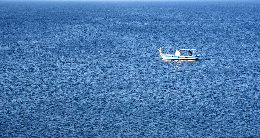 Lonely fishing Boat sailing on a calm blue sea Photograph by Michalakis Ppalis