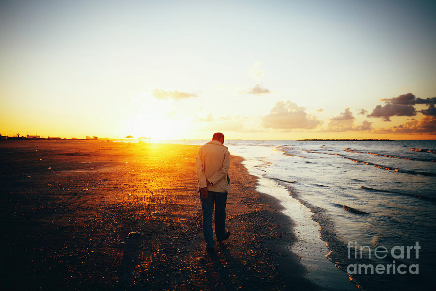 Lonely Man Walking On The Beach At Sunset. Photograph
