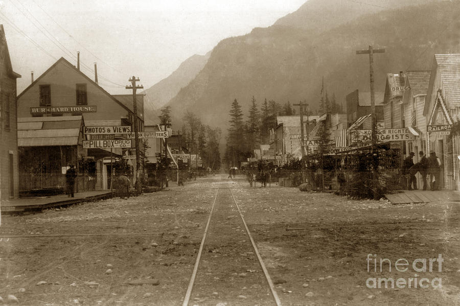 White Pass & Yukon Route Photograph - Looking down street with R/ R tracks Burrhard house White Pass and Yukon Route Railroad 1898 by Monterey County Historical Society