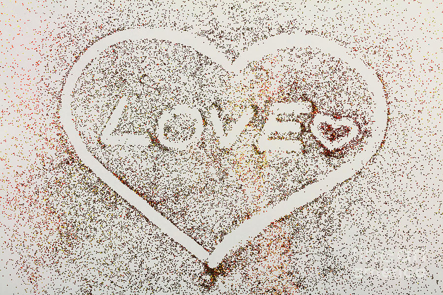 Love and heart written in glitter on white background. Photograph by Michal Bednarek