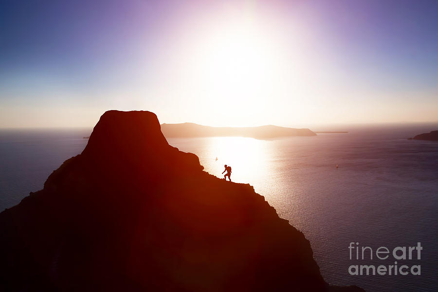 Sunset Photograph - Man climbing up hill to reach the peak of the mountain over ocean by Michal Bednarek