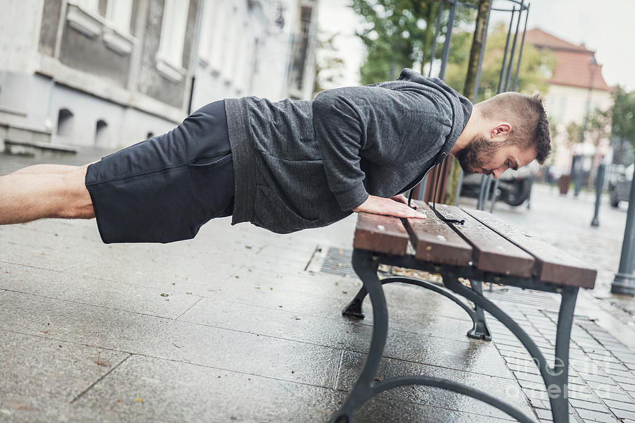 Man doing push-ups on a bench. Photograph by Michal Bednarek