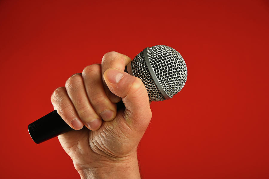 Man Hand With Microphone Over Red Background Photograph