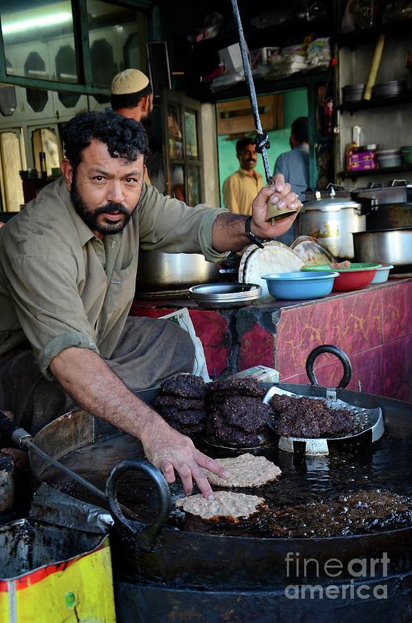 Man prepares Pakistani chapli kebab meat dish on skillet Gilgit Pakistan Photograph by Imran Ahmed