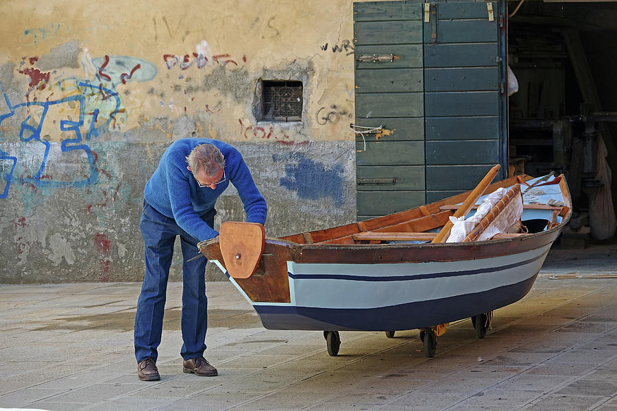 Man Repairing A Boat In Venice, Italy Photograph by Rick Rosenshein