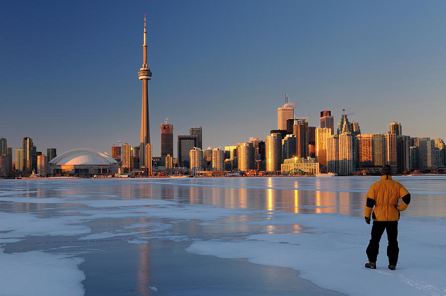 Man standing on frozen Lake Ontario ice looking at Toronto city  Photograph by Reimar Gaertner