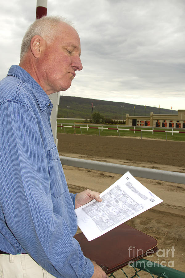 Man studying racing form trackside Photograph by Karen Foley