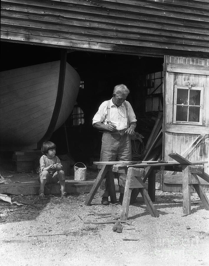 Summer Photograph - Man Woodworking While Boy Looks On by H. Armstrong Roberts/ClassicStock