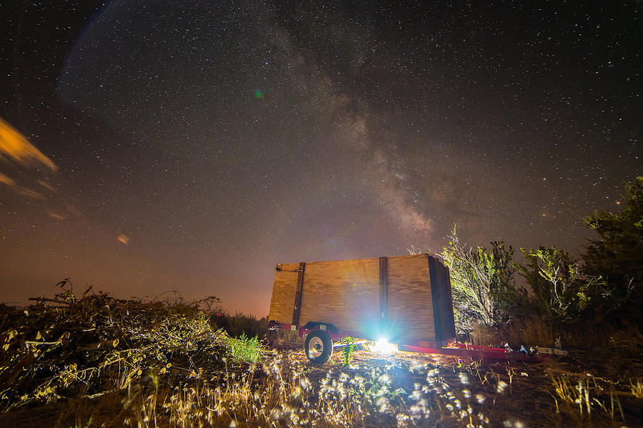 Milky Way Over Trailer in Rural Setting Illuminated by Light Underneath During Summer Photograph by Brian Ball