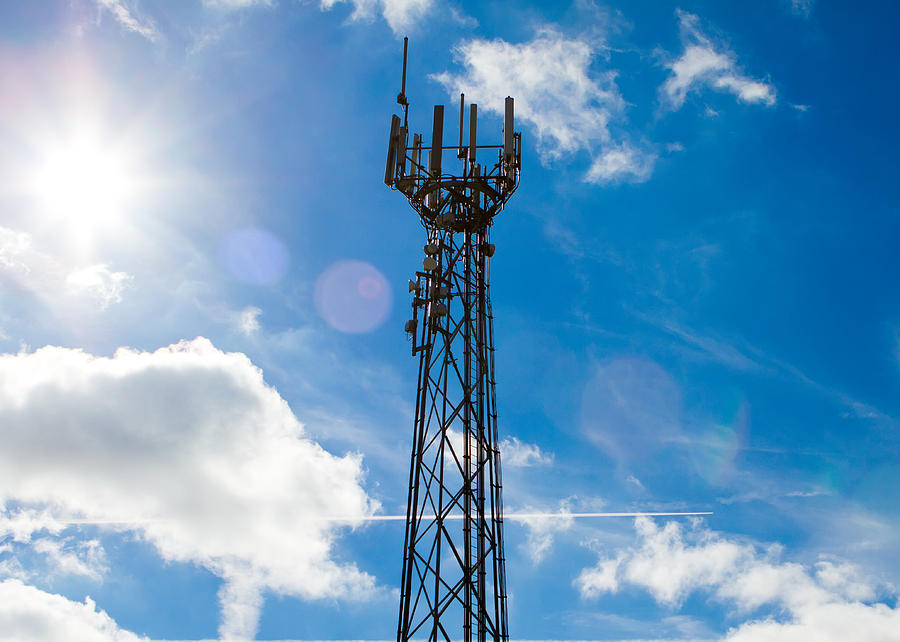 Aerial Photograph - Mobile phone mast with a blue sky behind by Fizzy Image