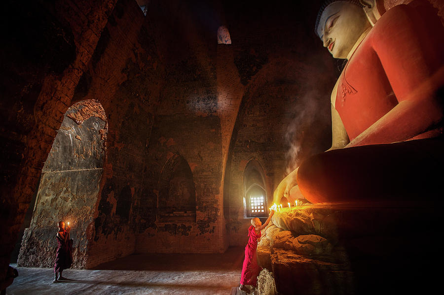Monk in Bagan old town pray a buddha statue with candle Photograph by Anek Suwannaphoom
