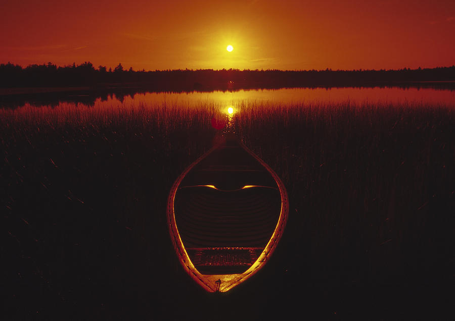 Moody sunrise lake scene with cedar canoe Photograph by Gary Corbett