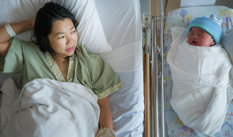 Bed Photograph - New born baby just delivery sleep with his mother in hospital by Anek Suwannaphoom