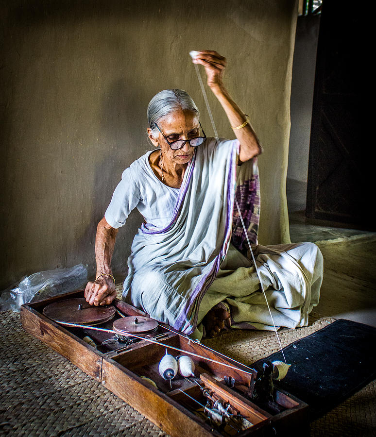 The mysterious old lady is rolling a traditional spinning wheel in