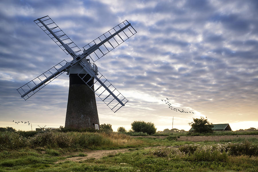 Old pump windmill in English countryside landscape early morning ...