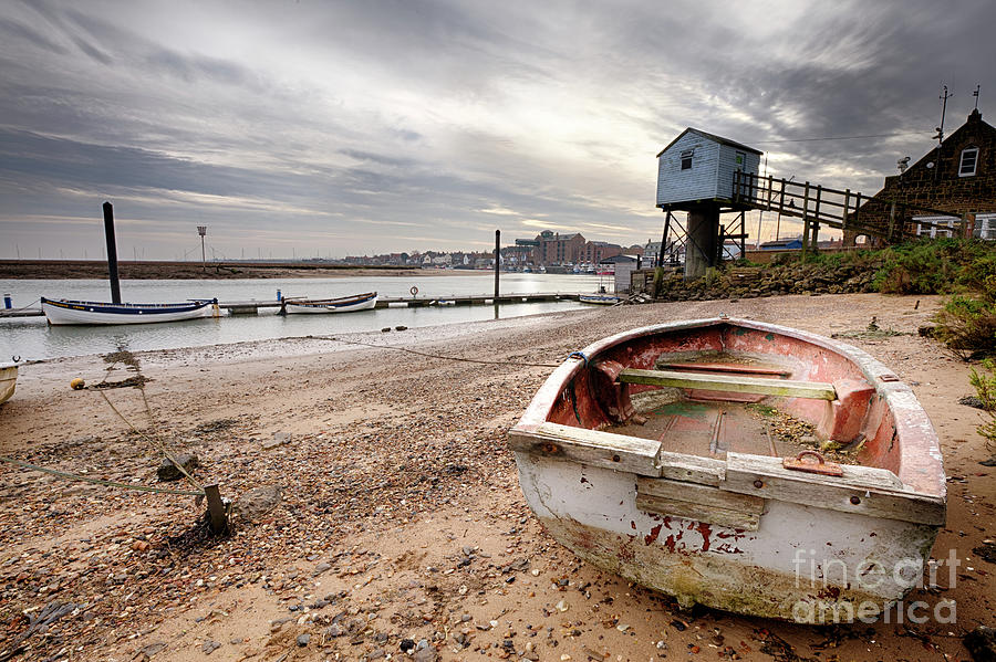Old rowing boat and lookout tower on beach Photograph by Simon Bratt