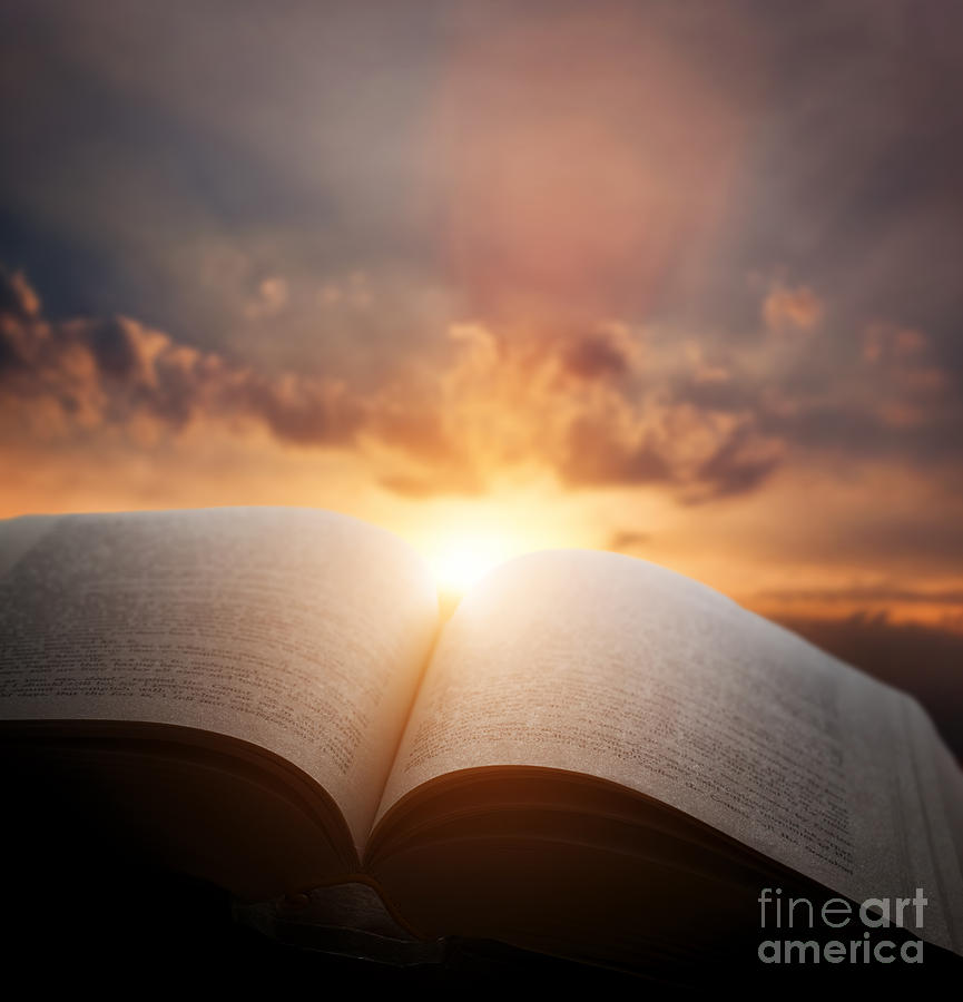 Open old book with light from sunset sky Photograph by Michal Bednarek