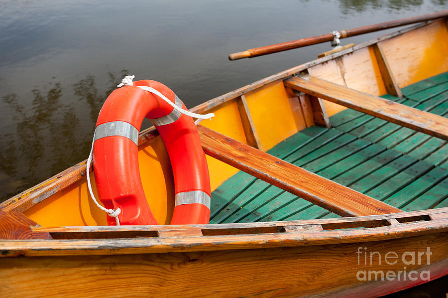Orange life belt in wooden boat Photograph by Arletta Cwalina