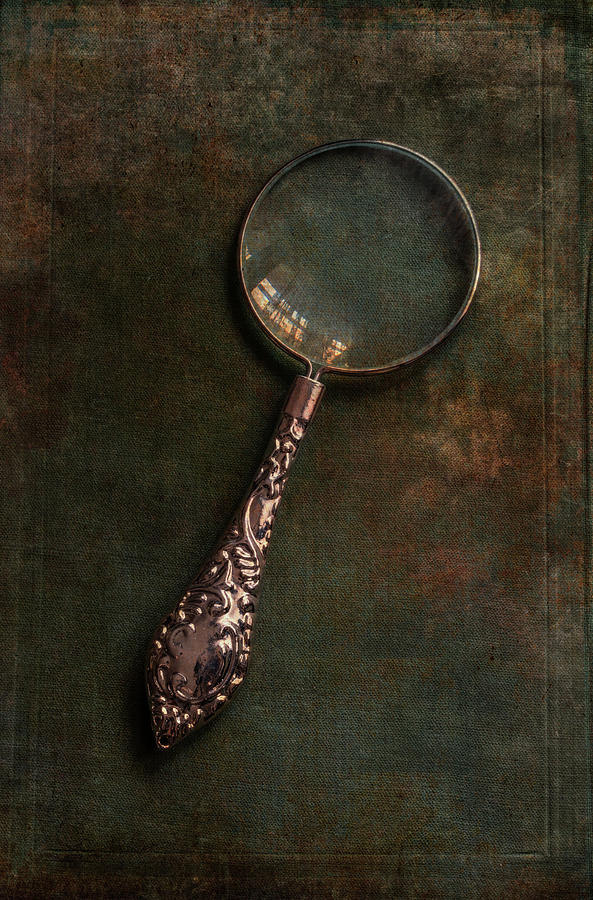 Ornamented magnifying glass  on old green book  Photograph by Jaroslaw Blaminsky