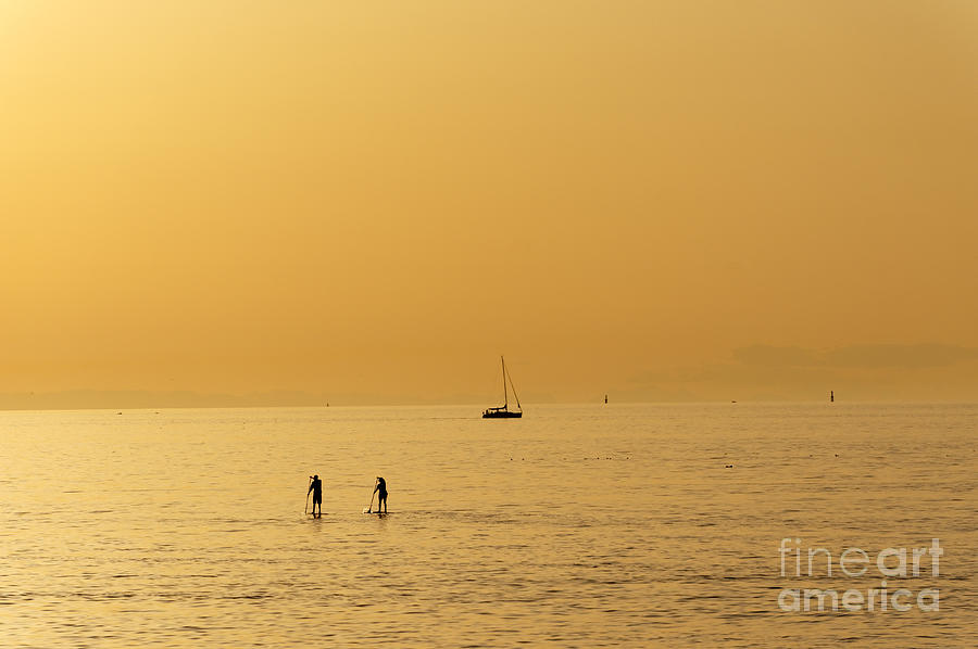 Paddle boarders at sunset Photograph by John  Mitchell