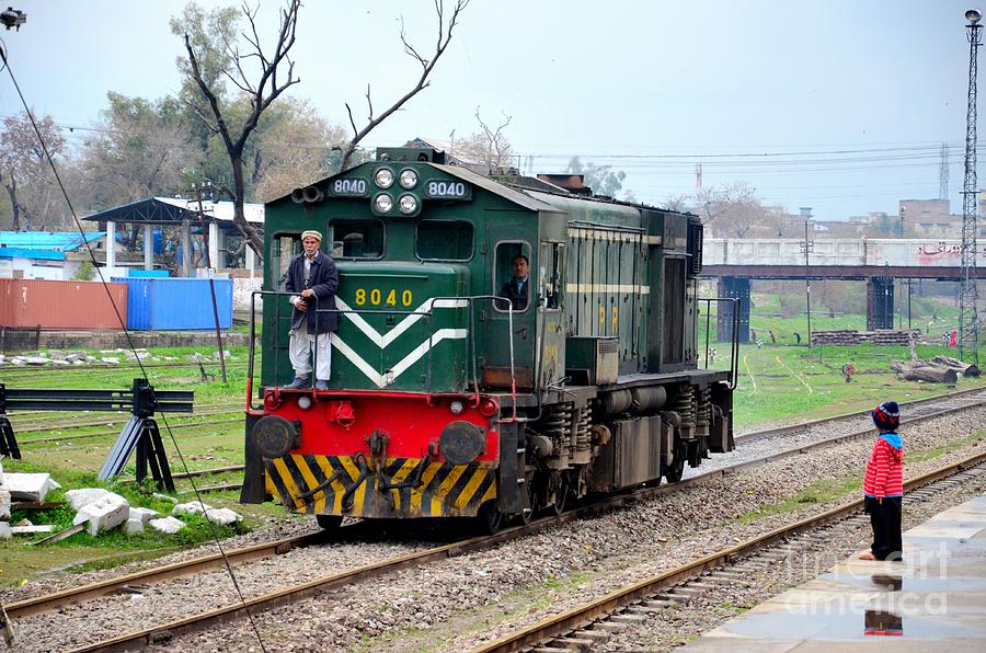 Pakistan Railways locomotive engine passes Peshawar station as small child watches Photograph by Imran Ahmed
