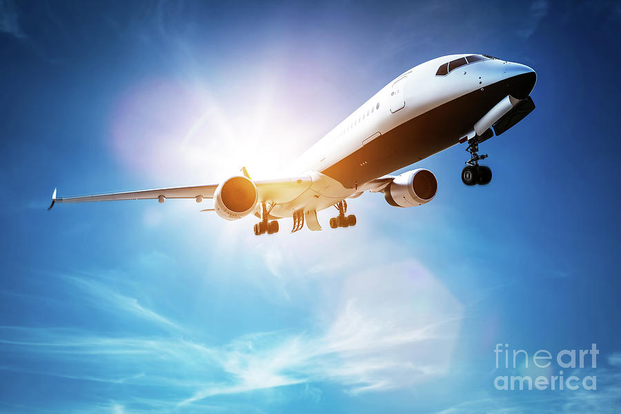 Passenger airplane taking off, sunny blue sky. Photograph by Michal Bednarek